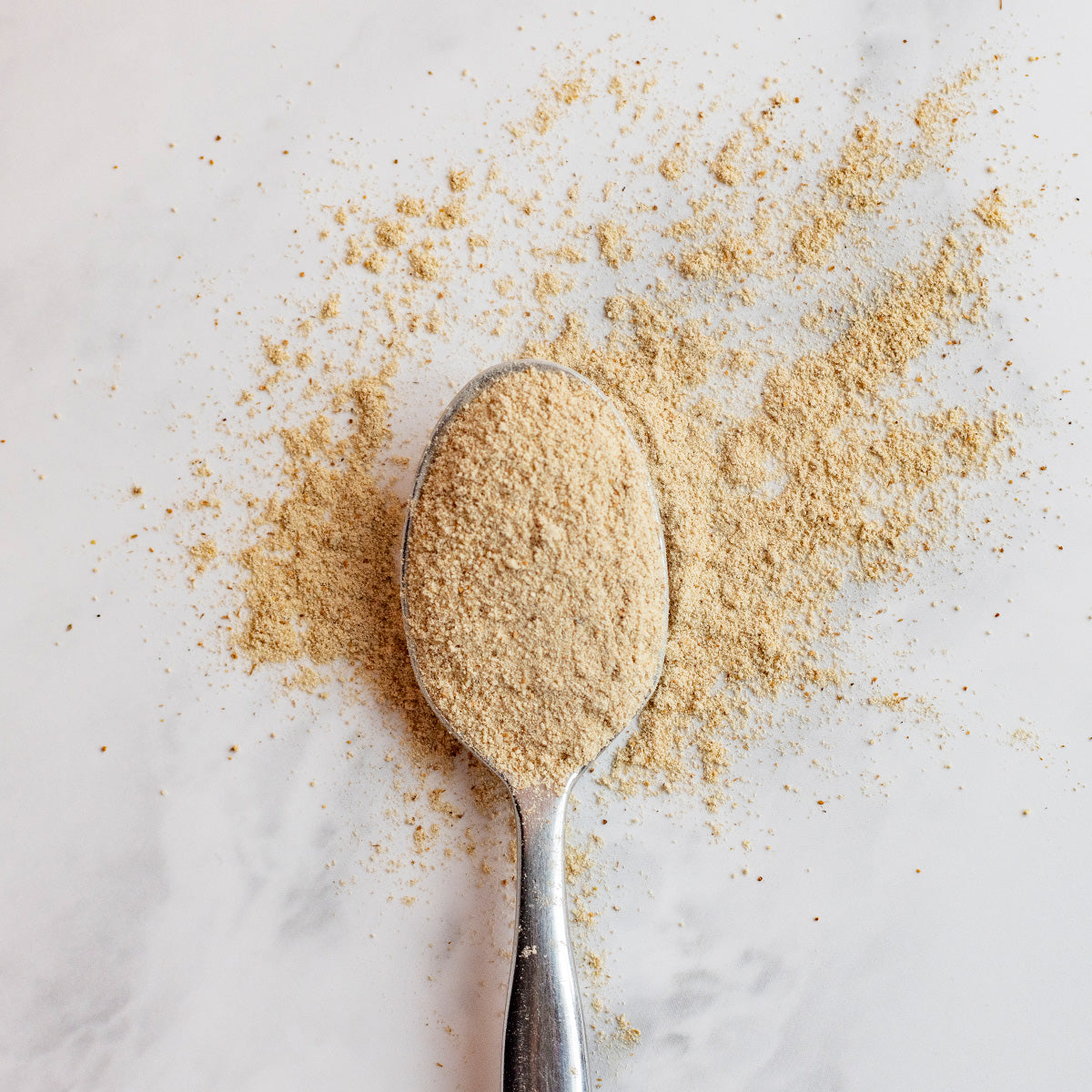 Spoonful of ashwagandha latte powder on a light background