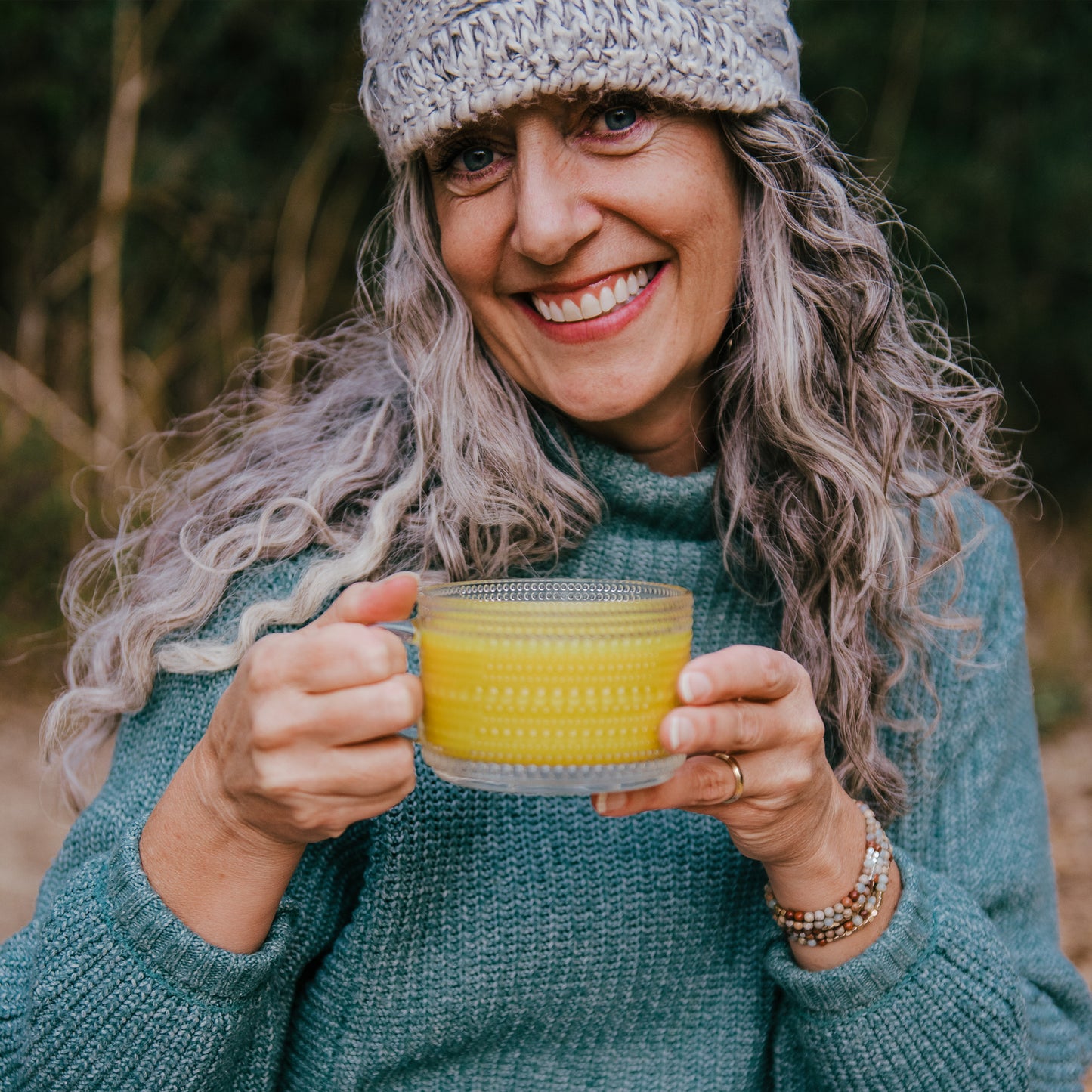 Woman holding a mug of Turmeric Milk outside. 